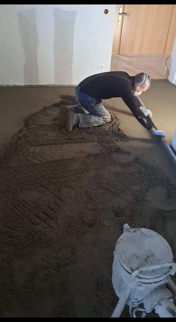 Michael Grabner beim Verarbeiten von frischem Estrich auf der Baustelle