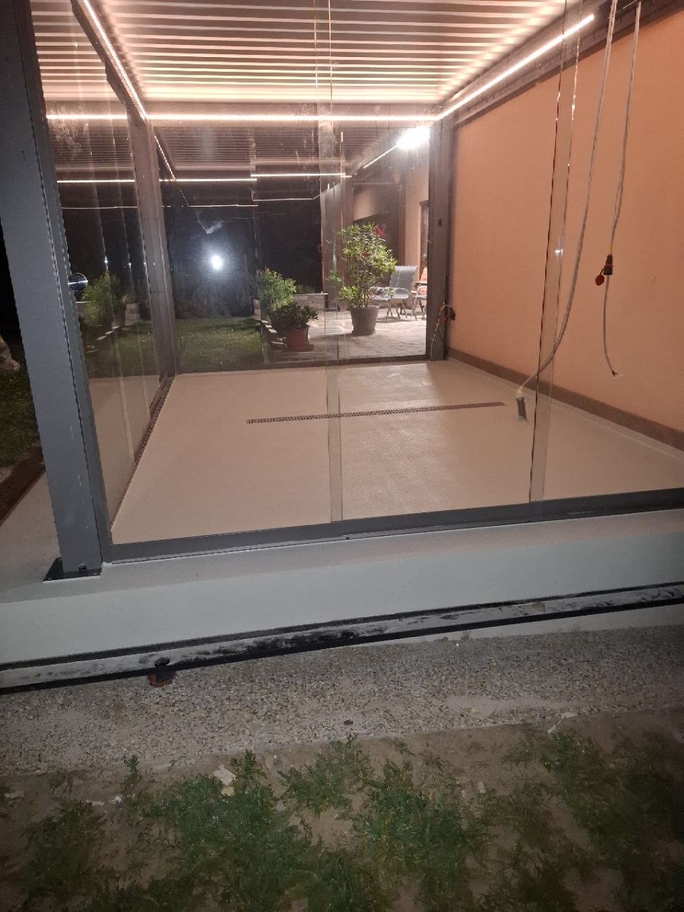 Von Grabner Estriche fertig verlegter Boden in einem modernen Wintergarten mit Glasfront